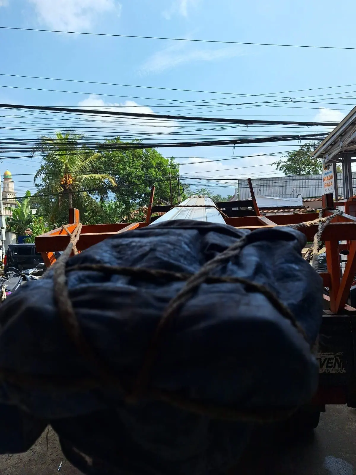 Truk pengangkut material baja di depan Toko Besi Niaga Baja